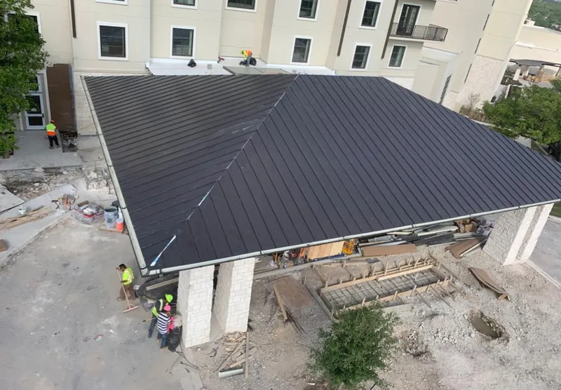 Metal roofing installation team working on a commercial building in Kenosha